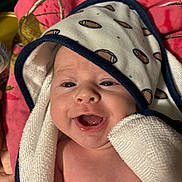 Karson is registered to the contest to win money with this photo: baby, smiling, towel, face, infant, closeup, happy, child, blanket, skin, head, person, cute, indoors, comfort, expression, newborn, wrapped, portrait, warm