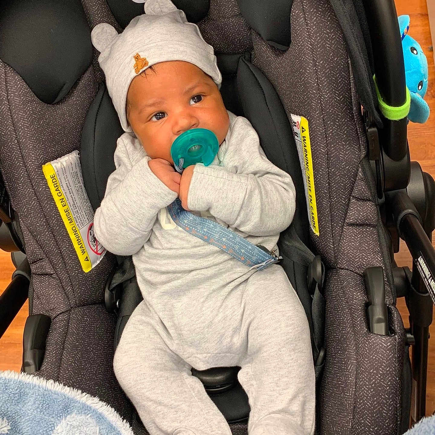 Jalynx is registered to the contest to win money with this photo: baby, baby_boy, blanket, car_seat, car_seat_strap, child, clothing, comfort, cute, evenflo, floor, footed_pajamas, hat, headwear, indoors, infant, pacifier, plush_toy, sitting, soft_toys