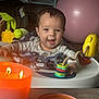 baby, child, smiling, toy, activity_center, candle, indoor, play, happy, face, person, table, colorful, exercise_ball, blanket, infant, lighting, closeup, home, cute