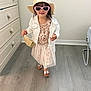 Mía Blanca is registered to the contest to win money with this photo: child, toddler, girl, face, pink_sunglasses, straw_hat, sun_hat, floral_dress, white_jacket, handbag, silver_sandals, wood_floor, dresser, indoor, wet_hair, smile, walking, accessories, cute, fashionable