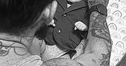 Noah is registered to the contest to win money with this photo: baby, child, infant, sunglasses, suit, formalwear, adult, tattoo, arm, portrait, black_and_white, indoor, cushion, pillow, seated, fashion, family, parent, close_up, humorous