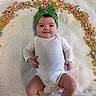 Mikiah is registered to the contest to win money with this photo: baby, blanket, bow, cereal, cute, eyes, face, food, hair, hand, headband, indoors, infant, legs, marshmallows, onesie, portrait, smile, snack, soft_texture