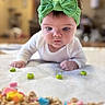 Mikiah joined the competition — help win amazing prizes! adorable, baby, blanket, blurred_foreground, bokeh_background, cheerios, closeup, curious, eyes, face, green_bow, hands, headband, indoor, infant, portrait, soft_texture, toy_cereal, tummy_time, white_onesie