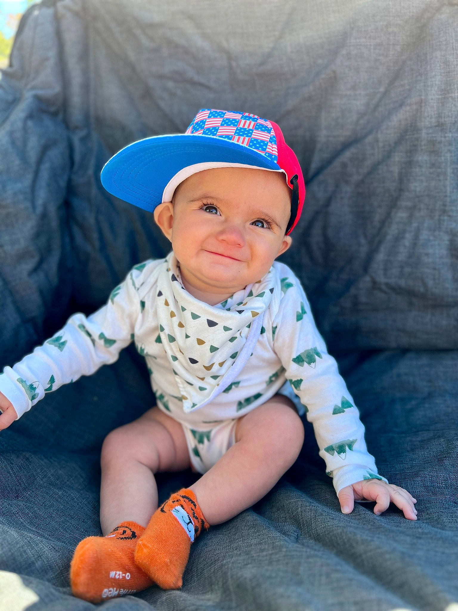 Lincoln is registered to the contest to win money with this photo: baby, baby_toddler_clothing, baseball_cap, cap, child, comfort, cool, electric_blue, eye, fun, happy, hat, headwear, joy, pattern, person, sitting, sleeve, smile, t_shirt