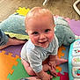 baby, child, smiling, indoor, playmat, toy, plush_toy, foot, hand, colorful, floor, crawling, person, cute, infant, clothing, musical_toy, happy, blue_eyes, playroom