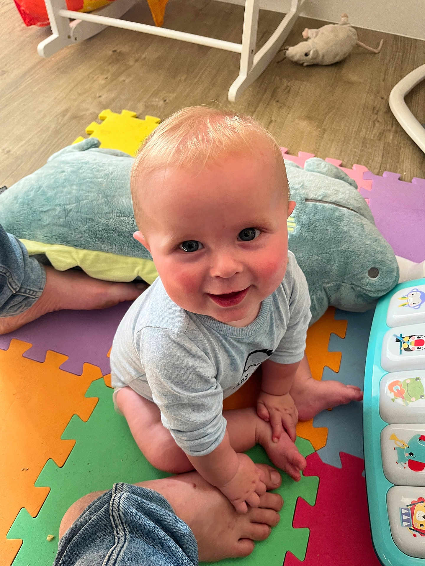 Oliver is registered to the contest to win money with this photo: baby, child, smiling, indoor, playmat, toy, plush_toy, foot, hand, colorful, floor, crawling, person, cute, infant, clothing, musical_toy, happy, blue_eyes, playroom