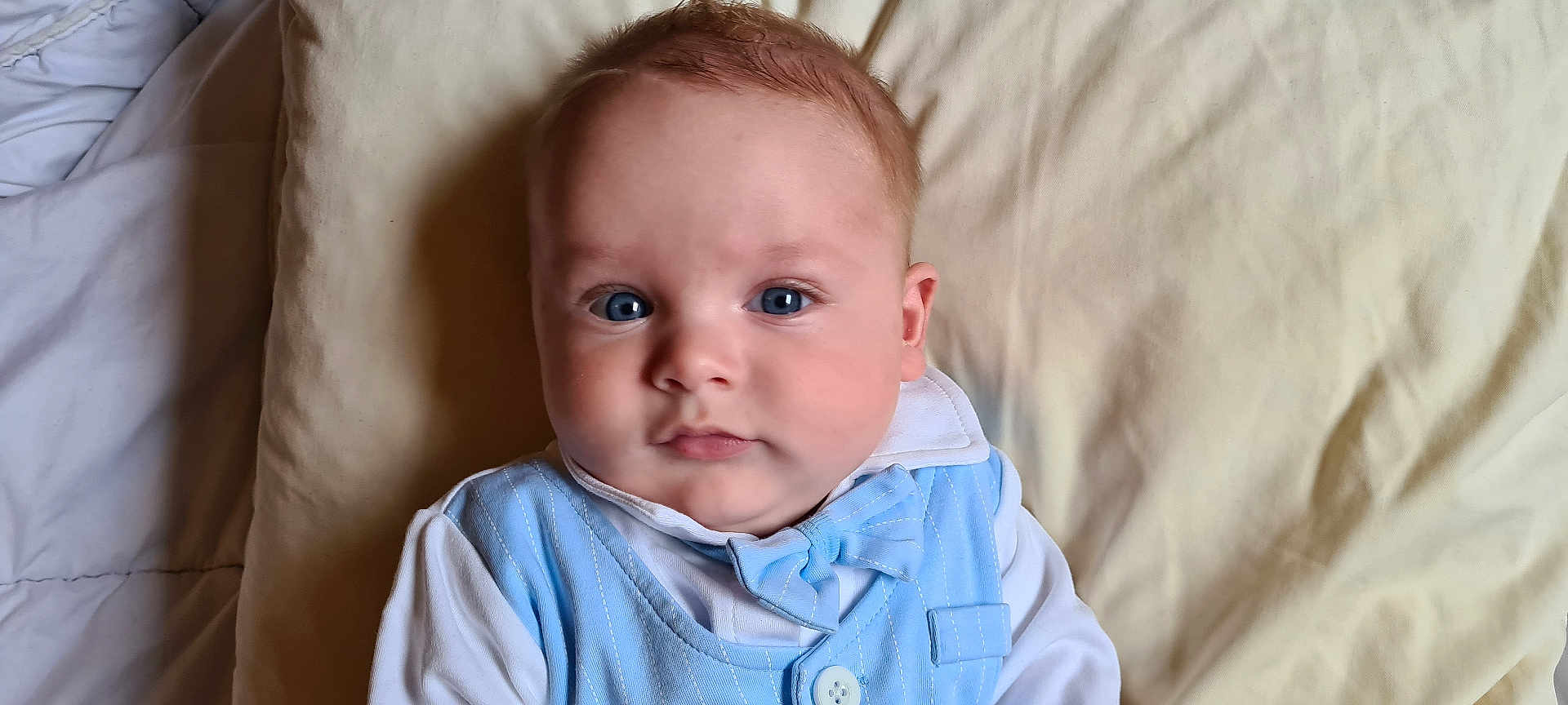 Ilyas a rejoint le concours — aidez-le/la à gagner de superbes lots ! baby, infant, blue_eyes, bow_tie, clothing, pillow, bed, blanket, face, child, portrait, indoors, cute, young, person, sleepwear, newborn, soft, resting, closeup