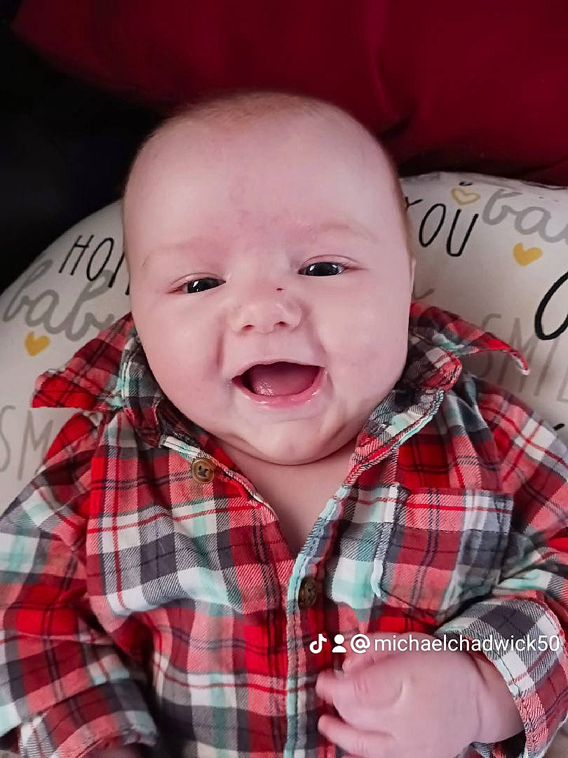 Michael is registered to the contest to win money with this photo: baby, cheek, child, chin, collar, comfort, dress_shirt, happy, mouth, pattern, person, plaid, red, skin, sleeve, smile, tartan, textile, toddler, tooth