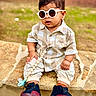 toddler, child, sunglasses, shirt, pants, sneakers, stone, outdoor, grass, fashion, cute, baby, footwear, accessory, pacifier, casual, sitting, young_child, portrait, summer