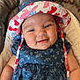 baby, smile, hat, blue_dress, floral_pattern, cushion, chair, face, child, cute, infant, happy, portrait, clothing, indoor, person, headwear, skin, baby_girl, sitting