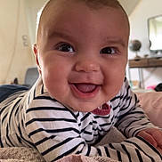 Elyana participe au concours pour gagner de l'argent avec cette photo : baby, child, smiling, striped_clothing, blanket, indoor, face, happy, toddler, drool, person, head, couch, soft_texture, home, portrait, cute, infant, cheerful, closeup