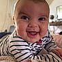 baby, child, smiling, striped_clothing, blanket, indoor, face, happy, toddler, drool, person, head, couch, soft_texture, home, portrait, cute, infant, cheerful, closeup