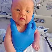 Cleo joined the competition — help win amazing prizes! newborn, baby, gloved_hand, hospital, medical_equipment, crib, clipboard, bed, infant, person, skin, face, hand, clothing, healthcare, patient, medical, hospital_room, closeup, expression