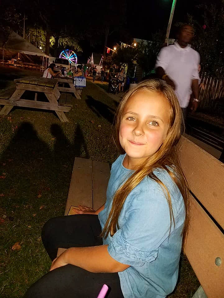 Marissa is registered to the contest to win money with this photo: fawn, fun, joy, long_hair, night, person, smile, under_exposed