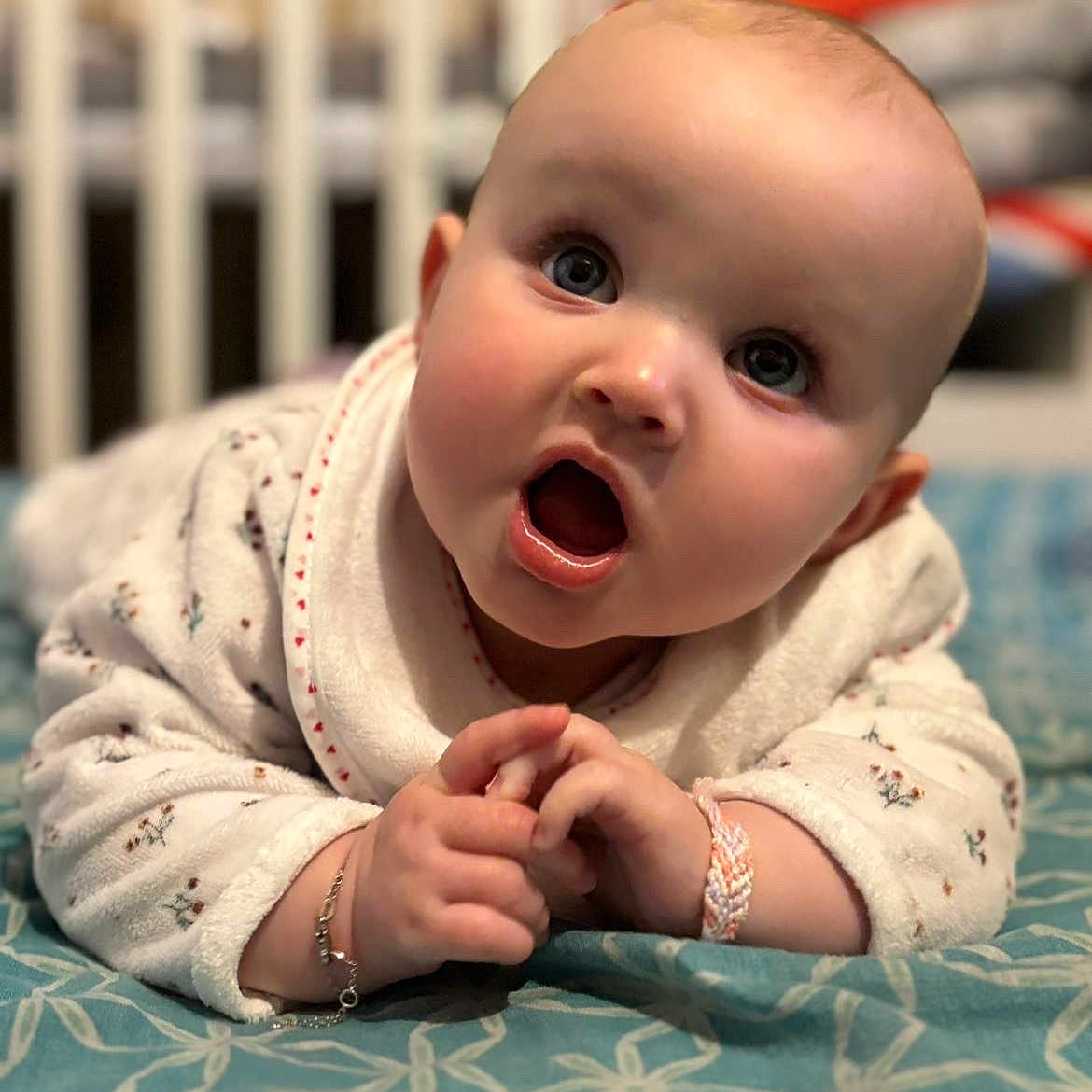 Leona participe au concours pour gagner de l'argent avec cette photo : baby, background, blanket, blue, bracelet, child, closeup, clothing, crib, cute, expression, face, hands, indoor, infant, pattern, portrait, sleepwear, soft, white