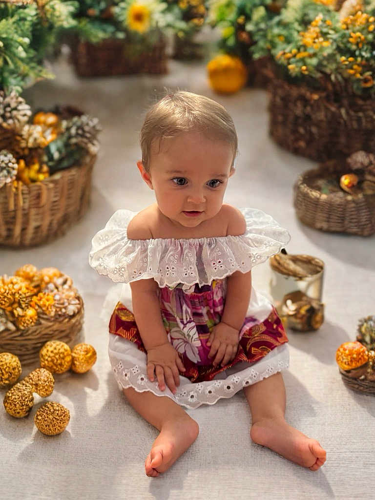 Abigaëlle a rejoint le concours — aidez-le/la à gagner de superbes lots ! baby, child, dress, sitting, baskets, dried_flowers, indoor, curious, colorful_clothing, barefoot, decor, natural_light, floor, portrait, infant, cute, hands, feet, closeup, soft_light