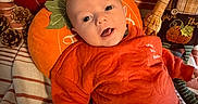 Mark joined the competition — help win amazing prizes! baby, child, infant, autumn, pumpkin, orange_outfit, smiling, happy, portrait, face, eyes, open_mouth, lying_down, cushion, blanket, pillows, fall_decor, pinecones, indoor, seasonal_decoration