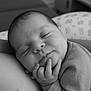 Esmée participe au concours pour gagner de l'argent avec cette photo : baby, infant, sleeping, black_and_white, portrait, peaceful, smile, hand, face, closeup, soft, resting, cozy, newborn, cute, child, calm, fingers, skin, clothing