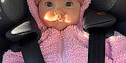 Esmée participe au concours pour gagner de l'argent avec cette photo : baby, child, car_seat, pink_jacket, knit_hat, pom_poms, wide_eyes, infant, cute, warm_clothing, seatbelt, straps, portrait, indoors, sunlight, face, expression, hand, winter_wear, cozy