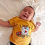Ilyan a rejoint le concours — aidez-le/la à gagner de superbes lots ! baby, smiling, yellow_shirt, pacifier, bed, white_bed_sheet, clothing, infant, happy, lying_down, dark_pants, folded_clothes, indoors, cute, child, person, toddler, face, small_hand, casual