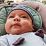 Ilyan a rejoint le concours — aidez-le/la à gagner de superbes lots ! baby, child, face, hat, blue_clothing, cushion, indoor, closeup, portrait, infant, cute, chubby_cheeks, relaxed, soft_lighting, headwear, patterned_fabric, seated, young_child, baby_outfit, adorable