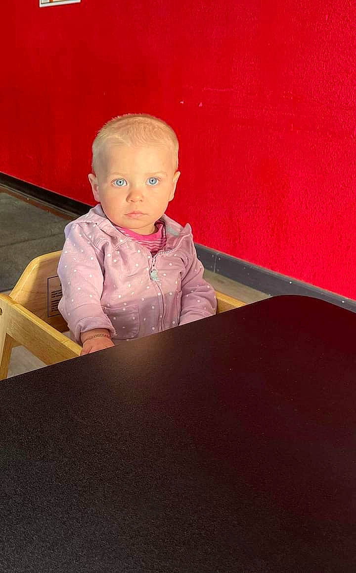 Angel is registered to the contest to win money with this photo: baby, baby_toddler_clothing, cheek, child, chin, comfort, eye, floor, flooring, hairstyle, hardwood, jacket, magenta, person, rectangle, room, sitting, sleeve, tints_and_shades, toddler