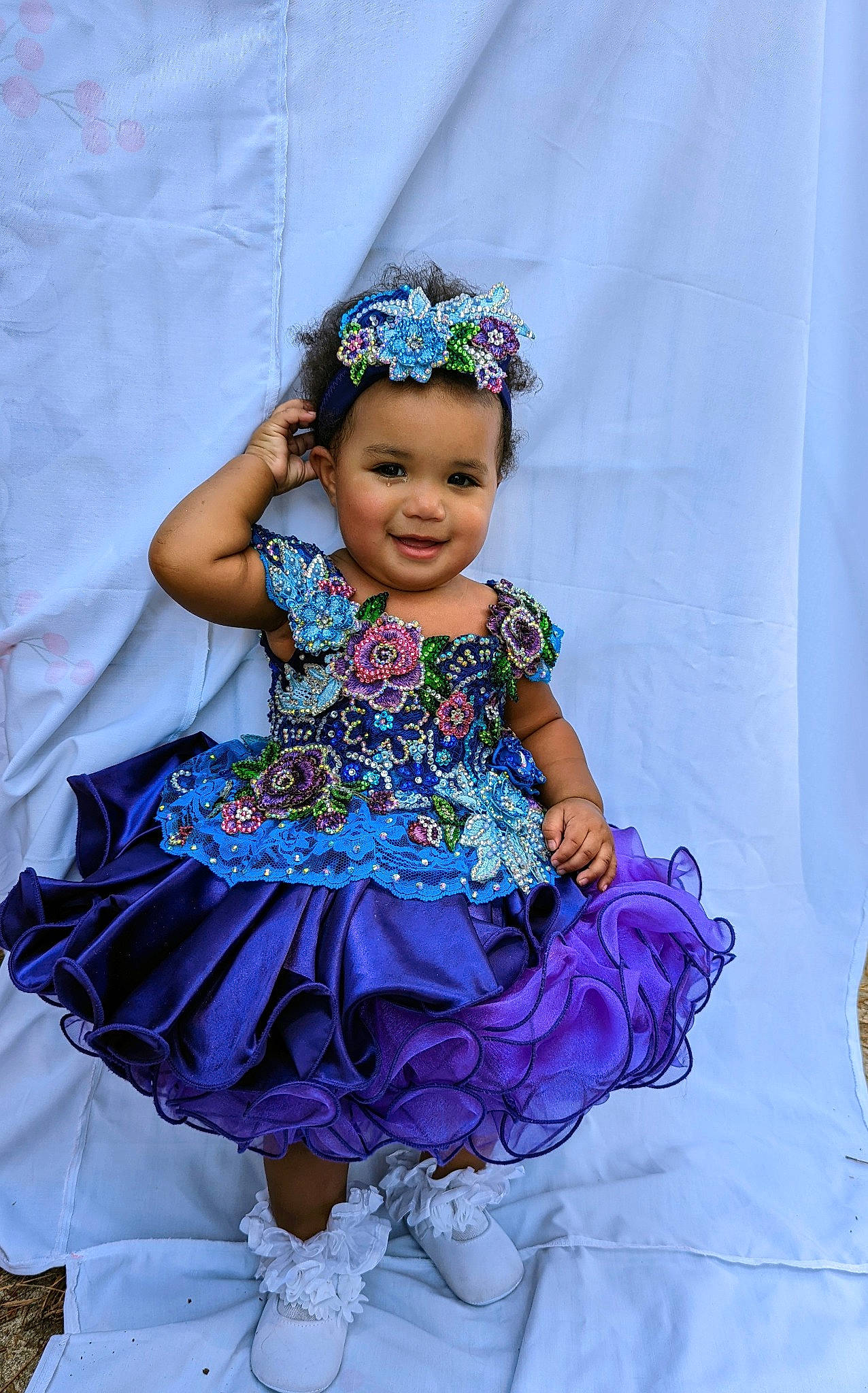 Talia is registered to the contest to win money with this photo: baby_toddler_clothing, blue, child, day_dress, dress, event, fashion_design, happy, headgear, headpiece, iris, jewellery, joy, magenta, necklace, person, pink, purple, ruffle, smile