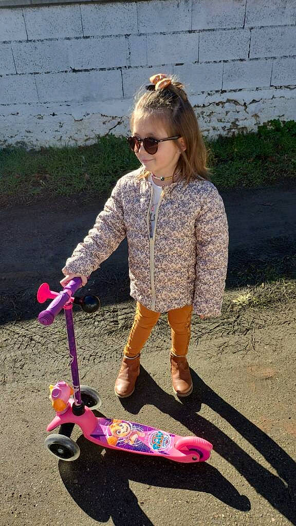 Carlie a rejoint le concours — aidez-le/la à gagner de superbes lots ! electric_blue, eyewear, fashion_accessory, fun, goggles, grass, happy, kick_scooter, magenta, person, pink, riding_toy, rolling, sleeve, sunglasses, tire, toddler, toy, vehicle, wheel