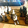 dog, chessboard, chess_pieces, indoor, couch, floor, sign, black_chess_pieces, white_chess_pieces, happy, pet, playful, large_objects, seating, tile_floor, waiting_area, relaxed, animal, board_game, leisure