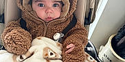 Harrison joined the competition — help win amazing prizes! baby, bear_pattern, blanket, brown_clothing, child, cozy, cute, eyes, face, floor, fuzzy_jacket, hand, hat, indoor, infant, pacifier, person, stroller, warm_clothing, wooden_floor