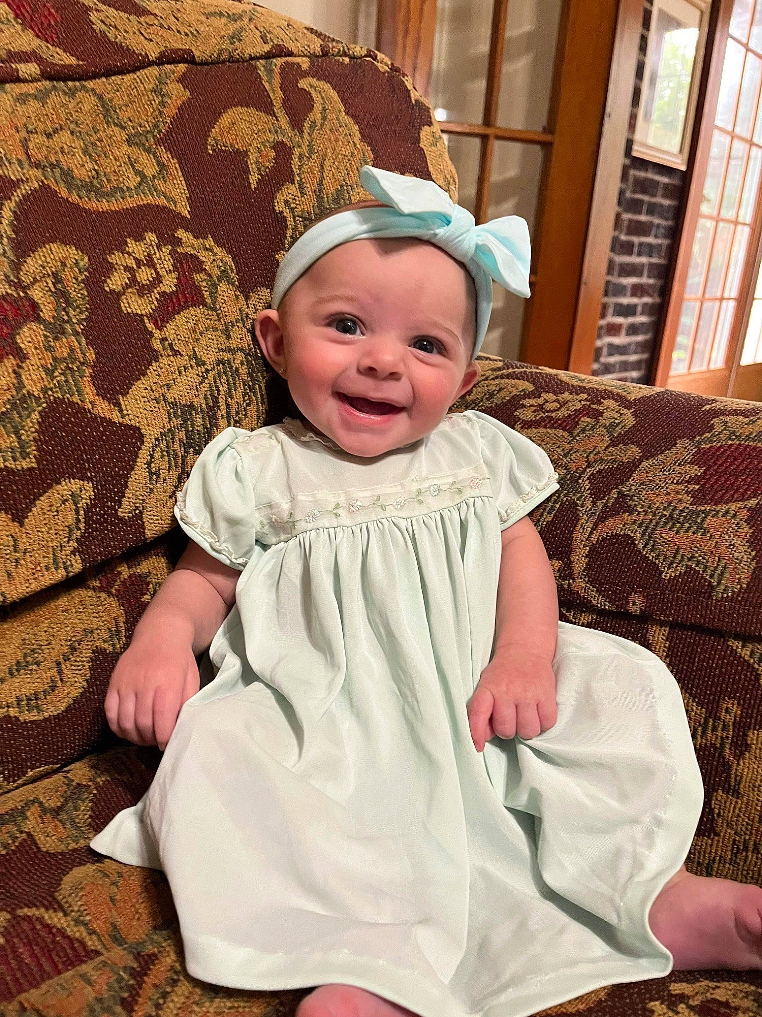 Quinn is registered to the contest to win money with this photo: baby, baby_toddler_clothing, child, comfort, couch, day_dress, event, face, fun, happy, hat, headgear, joy, pattern, person, pink, sitting, skin, sleeve, smile