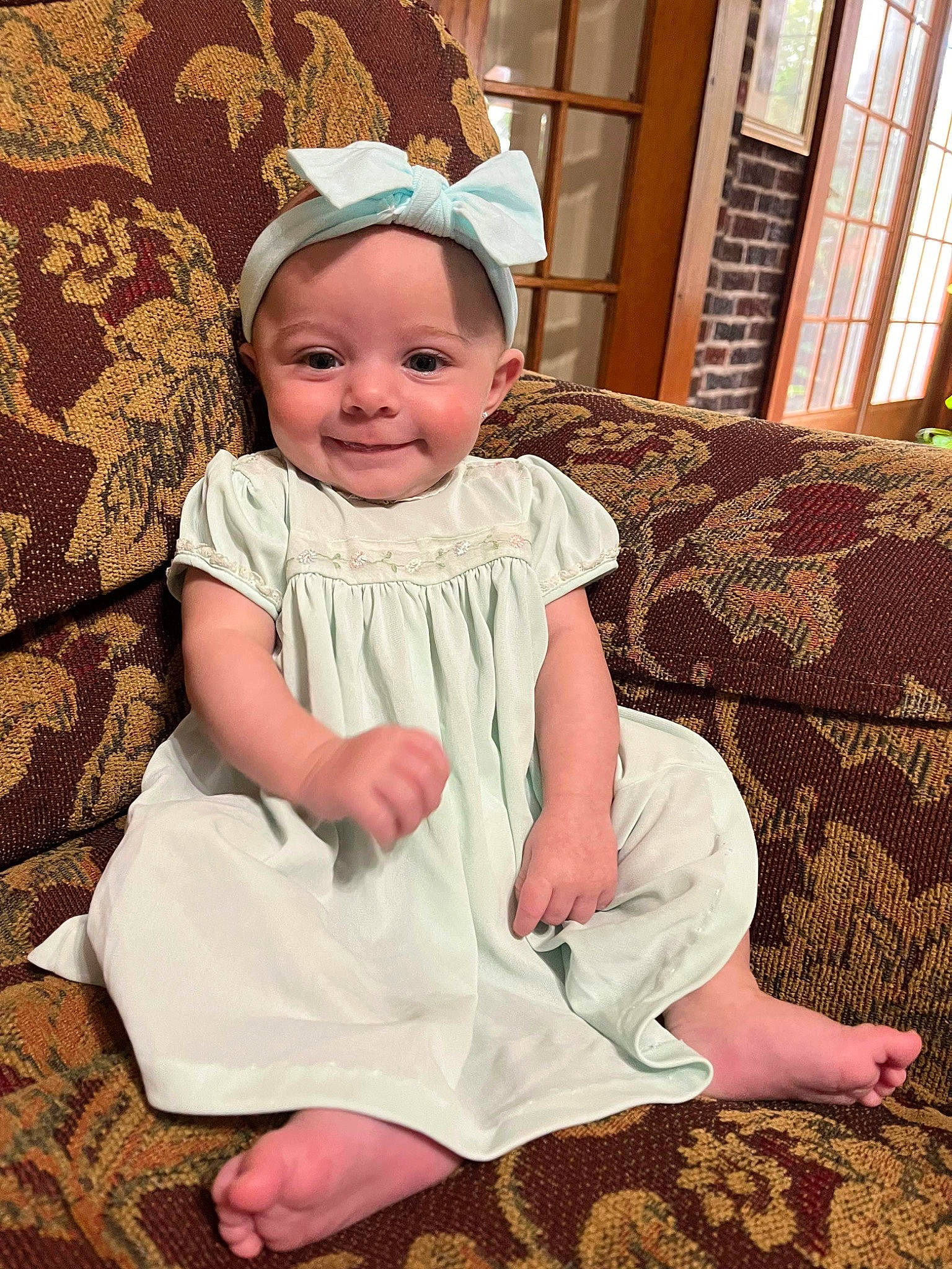 Quinn is registered to the contest to win money with this photo: baby, baby_toddler_clothing, cap, child, embellishment, event, face, fashion_accessory, happy, head, headband, headgear, joy, pattern, person, pink, sitting, skin, sleeve, smile