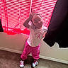 Londyn Rose is registered to the contest to win money with this photo: child, toddler, portrait, standing, smiling, peace_sign, braids, pink_pants, white_shirt, sneakers, indoor, bedroom, window, blinds, curtains, carpet, fashion, playful, natural_light, person
