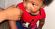 Tavon Jr joined the competition — help win amazing prizes! toddler, child, baby, portrait, standing, red_shirt, mickey_mouse, blue_pants, sneakers, curly_hair, tear, face, indoors, carpet, door, adult_hand, clothing, fashion, serious_expression, photography