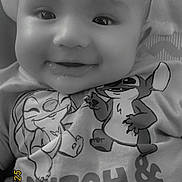 Codie is registered to the contest to win money with this photo: baby, smile, drool, shirt, cartoon, stitch, angel, closeup, black_and_white, child, face, happy, infant, clothing, text, toddler, cute, portrait, lying_down, soft