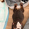 bulldog, puppy, dog, floor, wood_floor, dog_bed, plush_toy, black_toy, toy_monkey, pet, animal, paw, wrinkles, cute, indoor, laying_down, looking_up, pet_bed, brown, white