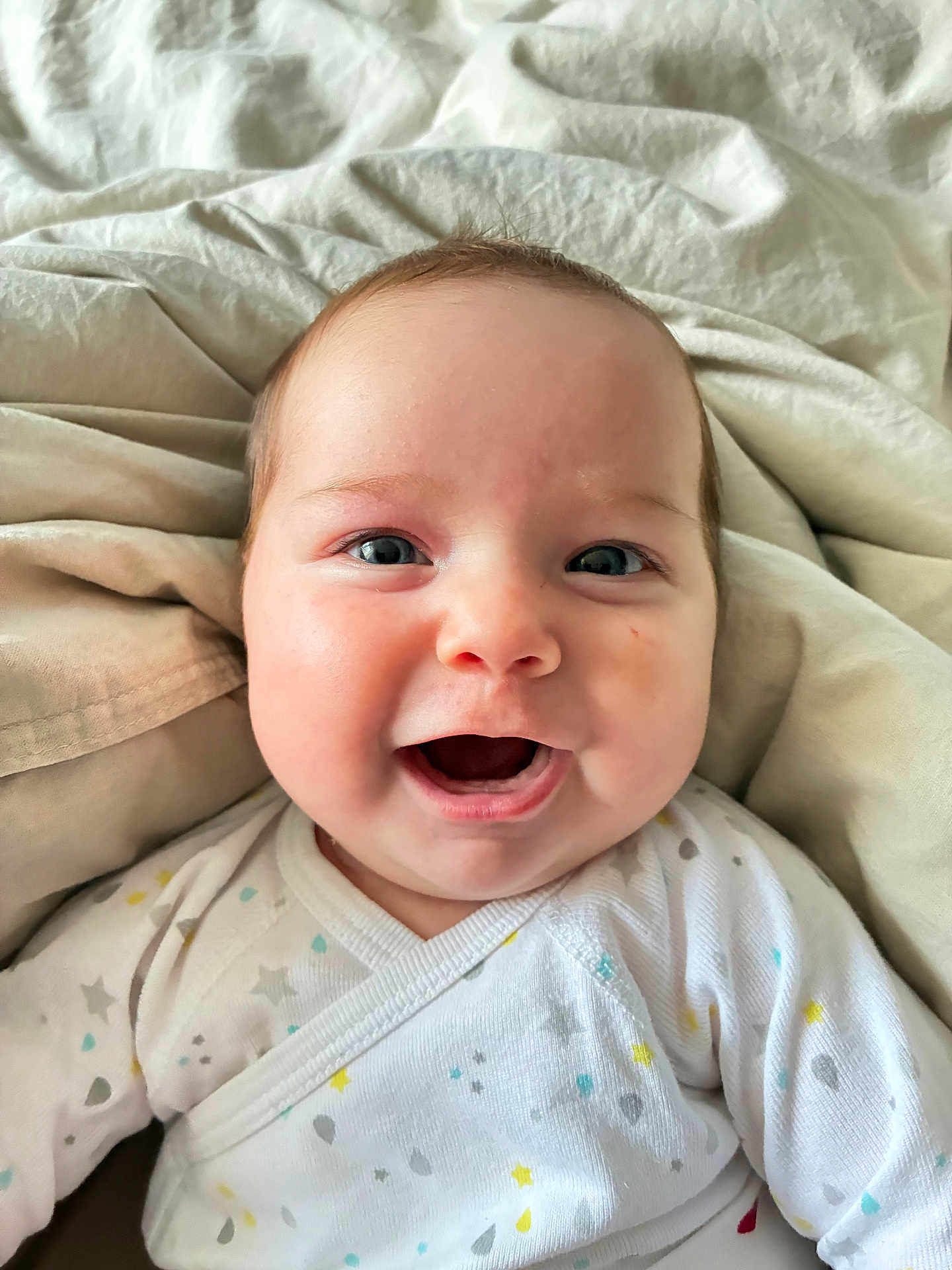 Aerith a rejoint le concours — aidez-le/la à gagner de superbes lots ! baby, smiling, closeup, face, infant, blanket, white_clothing, stars_pattern, raindrop_pattern, happy, cute, child, soft_texture, bed, cozy, newborn, portrait, human, eyes, mouth