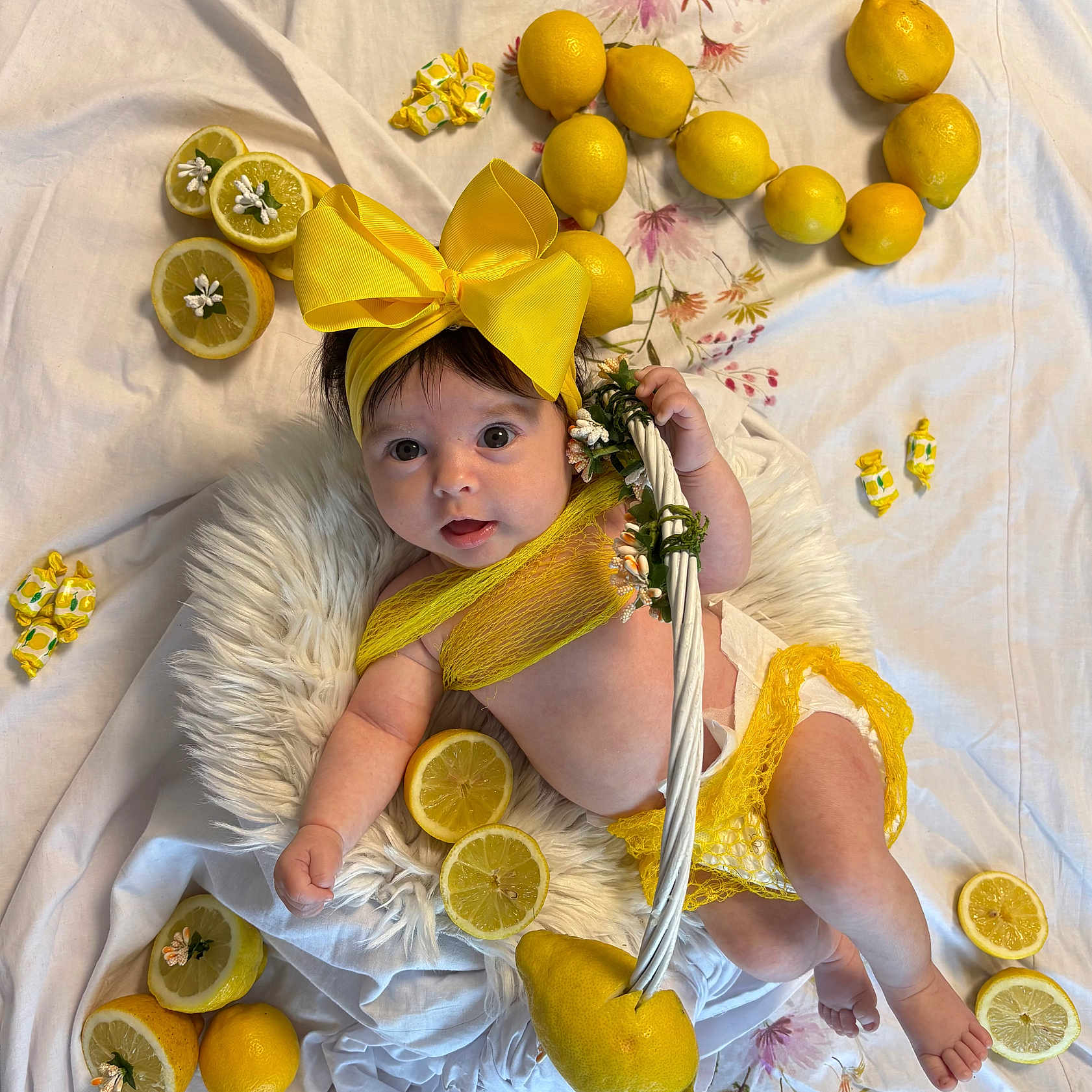 Baptistine participe au concours pour gagner de l'argent avec cette photo : baby, child, colorful, cute, diaper, fabric_background, flower_decoration, fruit, indoors, infant, lemon, lemon_slice, playful, portrait, resting, smiling, soft_texture, white_cushion, yellow_bow, yellow_clothing