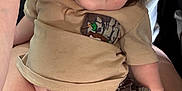 Asher is registered to the contest to win money with this photo: baby, child, person, blue_eyes, shorts, shirt, duck_patch, camo_pattern, lap, skin, hair, hand, curious, casual_clothing, indoor, close_up, portrait, relaxed, cute, infant