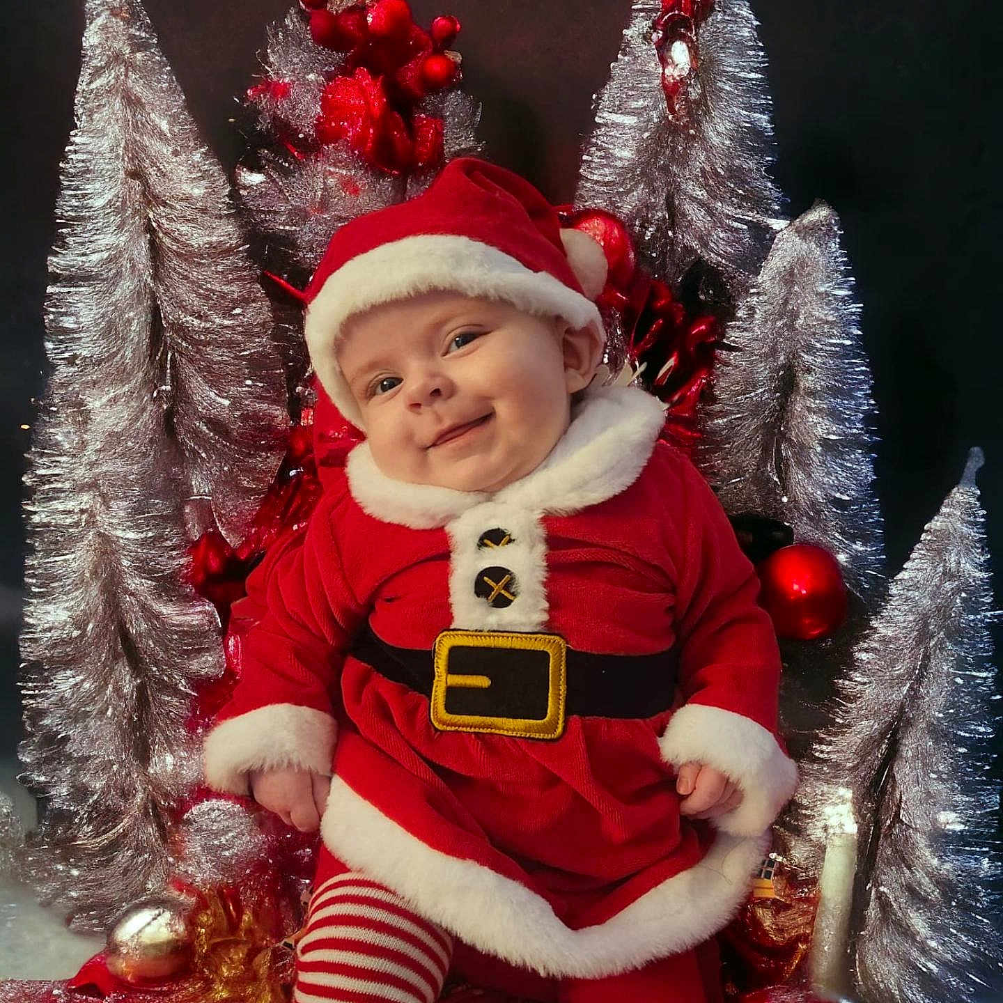 Isabelle is registered to the contest to win money with this photo: accessories, architecture, baby, ball, bodypart, bonnet, building, cap, christmas, christmasdecorations, christmastree, clothing, coat, costume, elf, face, festival, fir, football, furniture