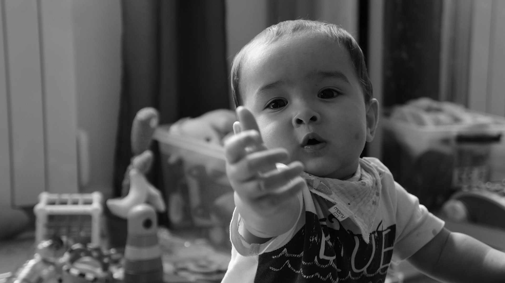 Liam a rejoint le concours — aidez-le/la à gagner de superbes lots ! toddler, child, baby, face, hand, indoors, black_and_white, curious, expression, toy, playroom, clothing, bandana, portrait, person, young_child, closeup, furniture, blurred_background, home
