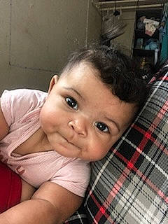 Charleigh is registered to the contest to win money with this photo: baby, baby_toddler_clothing, cheek, child, elbow, eyebrow, eyelash, finger, happy, iris, lip, nose, pattern, person, plaid, sitting, skin, smile, tartan, thumb