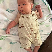 Zakai joined the competition — help win amazing prizes! baby, infant, child, overalls, clothing, blanket, leaf_pattern, lying_down, cute, small_hands, curious_expression, indoors, soft_lighting, palm_tree_print, fabric, skin, face, feet, newborn, portrait