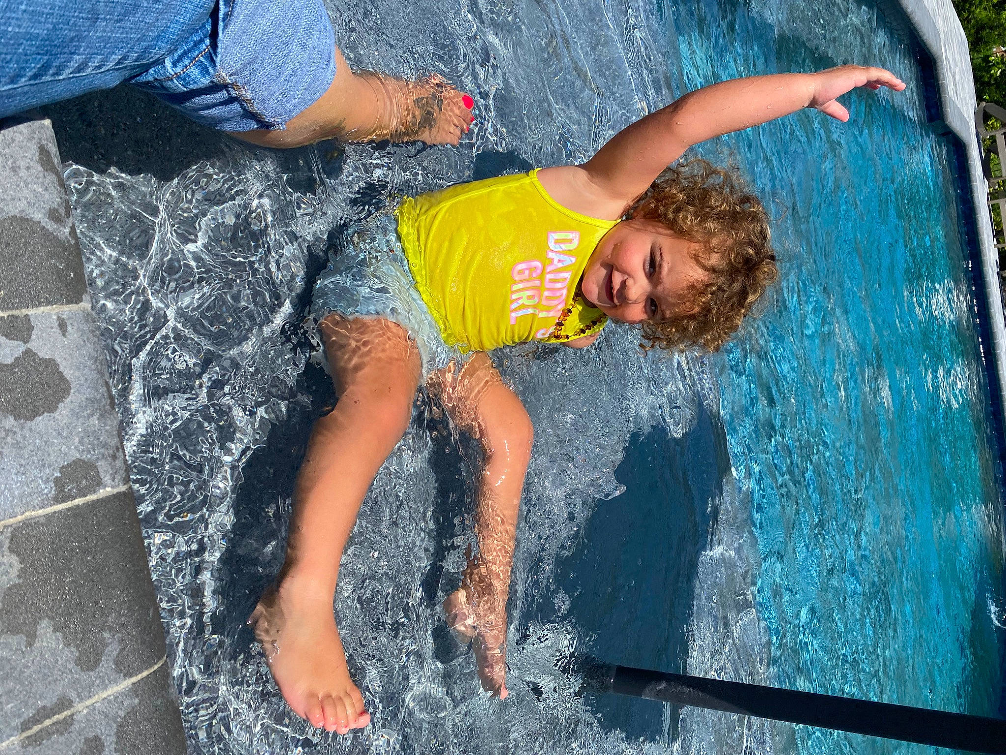 Memri is registered to the contest to win money with this photo: barefoot, bathing, blue, board_short, child, foot, fun, happy, human_leg, leisure, person, recreation, shorts, smile, swimming_pool, t_shirt, thigh, trunks, water, wave