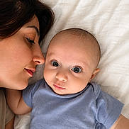 Daniel is registered to the contest to win money with this photo: baby, infant, mother, woman, face, portrait, closeup, bed, blanket, blue_clothing, skin, head, eyes, expression, love, affection, resting, indoor, people, parenting