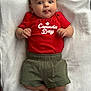 Brody is registered to the contest to win money with this photo: baby, infant, child, towel, red_shirt, green_shorts, tongue_out, cute, playful, lying_down, clothing, person, face, skin, hands, feet, indoors, expression, celebration, canada_day