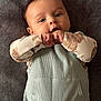 Brody is registered to the contest to win money with this photo: baby, infant, child, face, hands, clothing, blanket, texture, portrait, cute, lying_down, soft_fabric, long_sleeve, animal_print, skin, eyes, mouth, fingers, expression, indoors