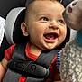 Brody joined the competition — help win amazing prizes! baby, car_seat, smile, happy, child, toy, infant, closeup, seatbelt, red_clothing, cute, face, expression, sitting, childrens_toy, black_straps, indoors, portrait, young_child, playful