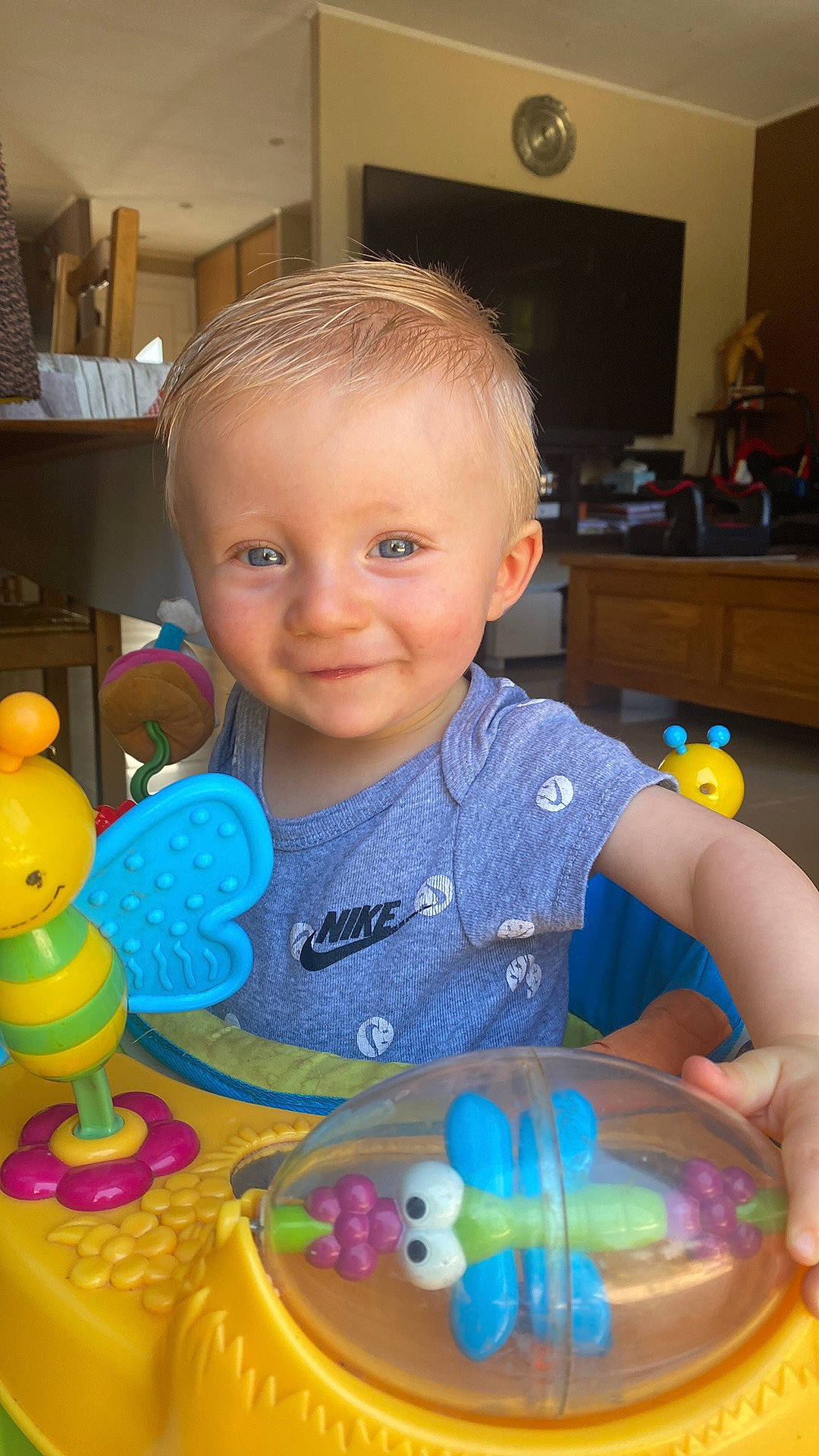 Maë participe au concours pour gagner de l'argent avec cette photo : baby, baby_products, baby_toddler_clothing, blue, cheek, child, clock, eye, fun, iris, joy, mouth, organ, person, plastic, room, skin, smile, television, toddler