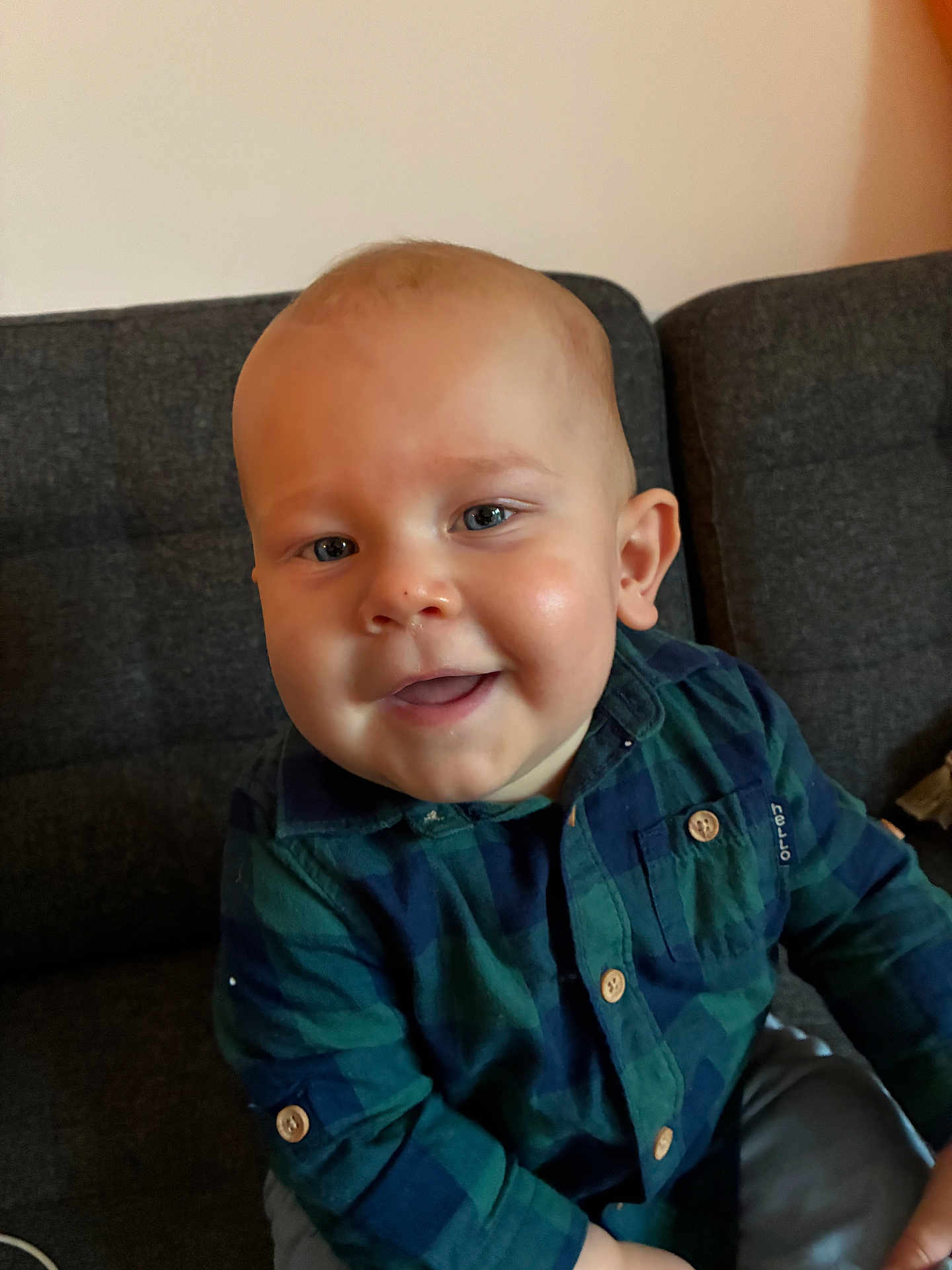 Noah participe au concours pour gagner de l'argent avec cette photo : baby, child, smile, face, plaid_shirt, blue_eyes, couch, indoor, person, happy, sitting, young_child, buttoned_shirt, casual_clothing, infant, cute, portrait, head, skin, cheerful